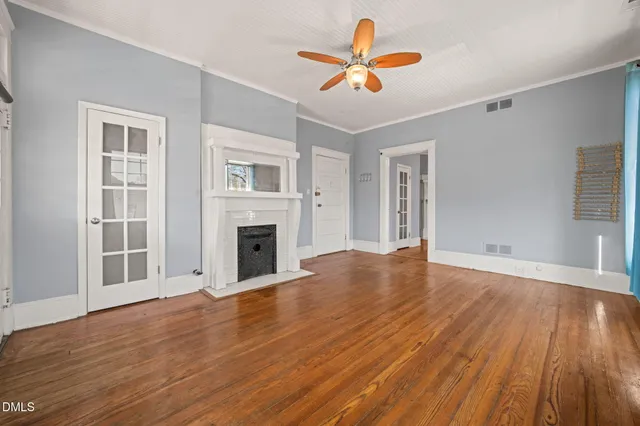 a view of a livingroom with wooden floor and a ceiling fan