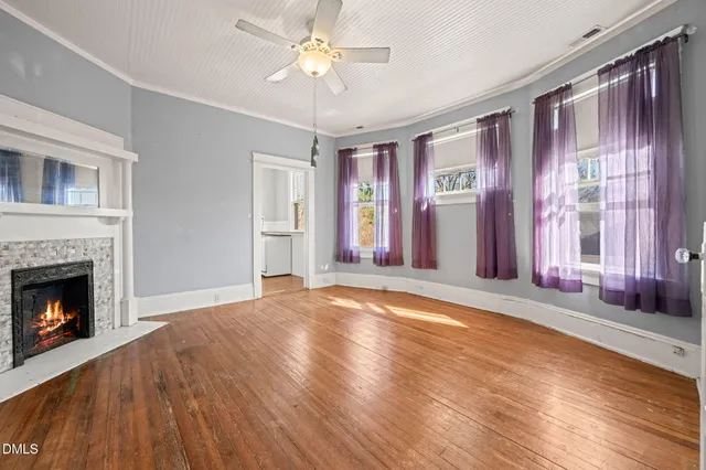 a view of an empty room with window and fire place