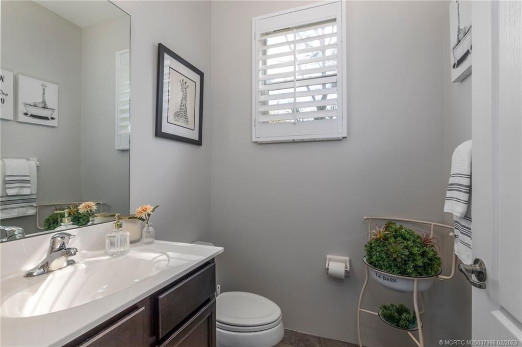 9574 Southwest Purple Martin Way Stuart, FL 34997 - Photo 12 of 32 a bathroom with a granite countertop toilet sink and mirror