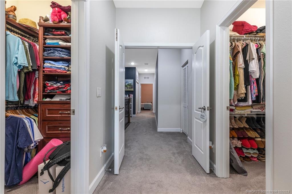 9574 Southwest Purple Martin Way Stuart, FL 34997 - Photo 17 of 32 a view of walk in closet with clothes and shoes