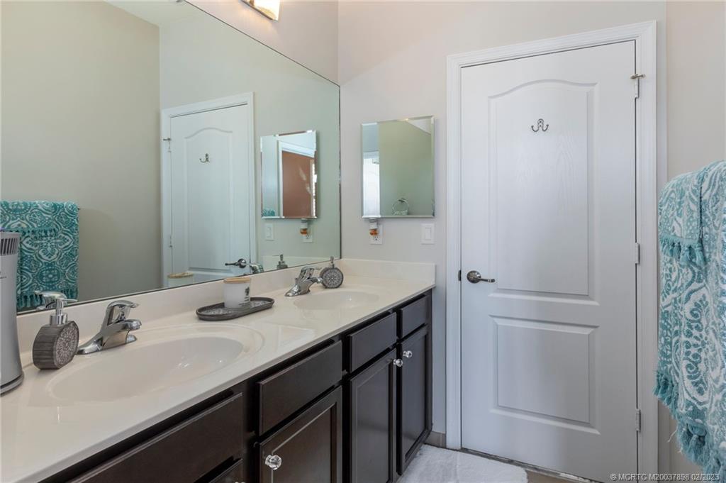 9574 Southwest Purple Martin Way Stuart, FL 34997 - Photo 20 of 32 a bathroom with a sink and a mirror