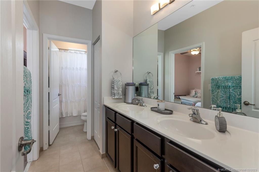9574 Southwest Purple Martin Way Stuart, FL 34997 - Photo 21 of 32 a bathroom with a sink and a mirror