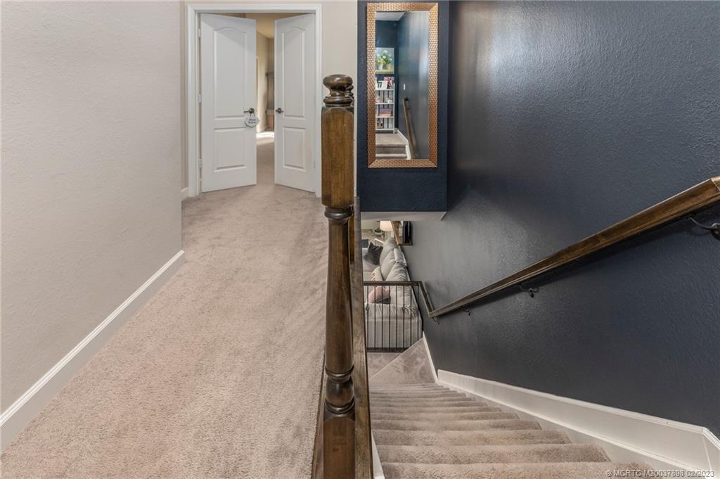 9574 Southwest Purple Martin Way Stuart, FL 34997 - Photo 23 of 32 a view of a hallway with wooden floor and staircase