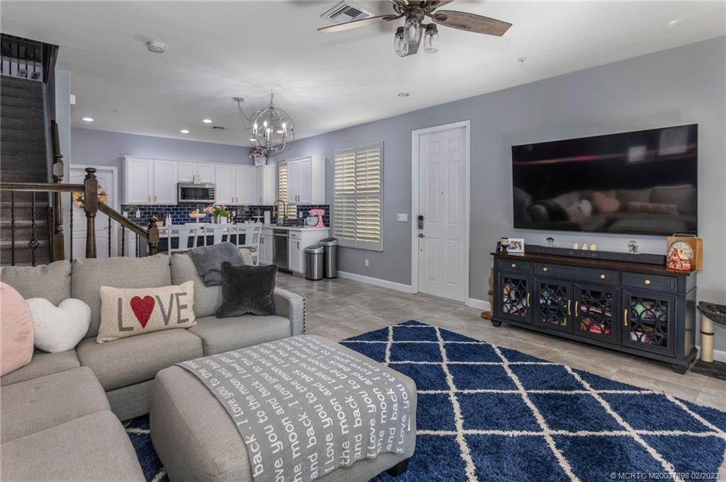 9574 Southwest Purple Martin Way Stuart, FL 34997 - Photo 6 of 32 a living room with furniture a flat screen tv and kitchen view