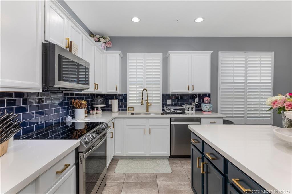 9574 Southwest Purple Martin Way Stuart, FL 34997 - Photo 10 of 32 a kitchen with a sink stove top oven and cabinets