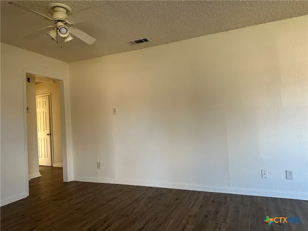 a view of room with wooden floor and fan
