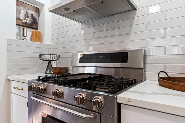 a stove top oven sitting inside of a kitchen