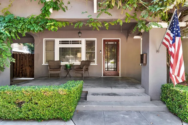 a front view of a house with garden and chairs