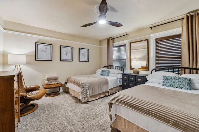 a bedroom with two beds and a large window