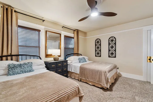 a bedroom with two beds and a large window