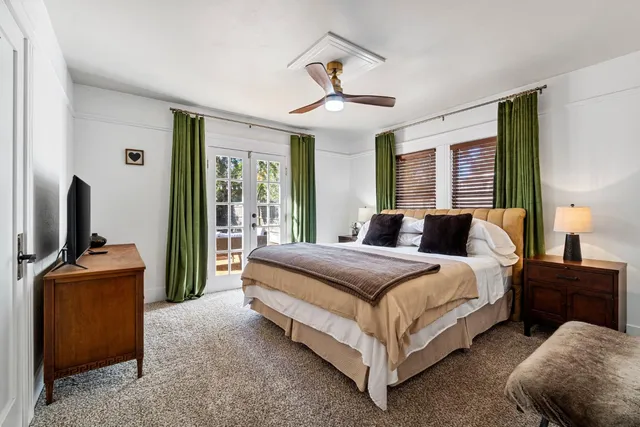 a spacious bedroom with a bed and wooden floor