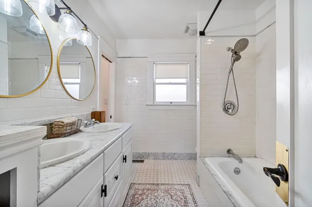 a bathroom with a tub sink and mirror