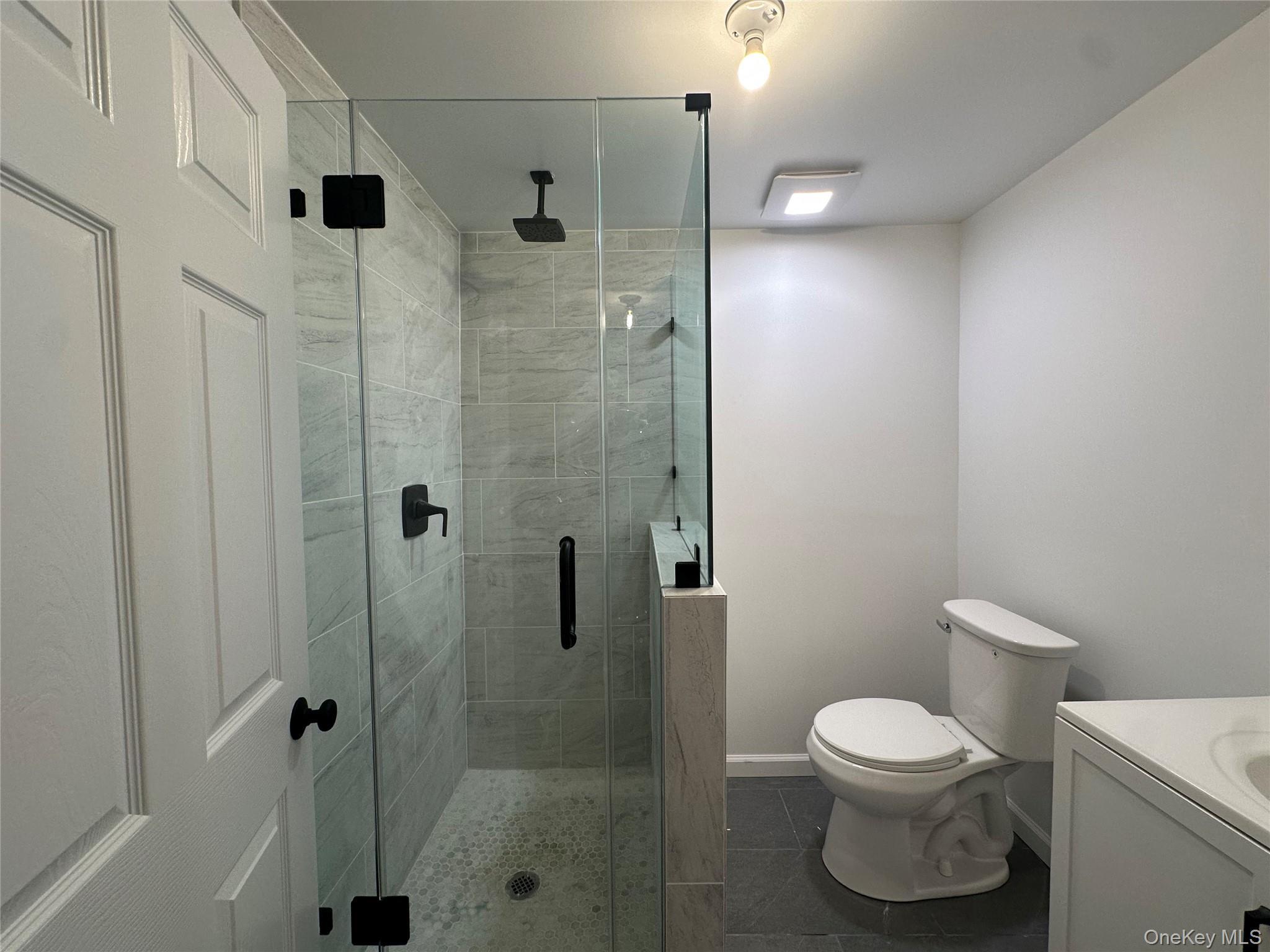 103 Sunrise Trail Wallkill, NY 12589 - Photo 13 of 24 Full bath with vanity, a stall shower, and dark tile patterned floors