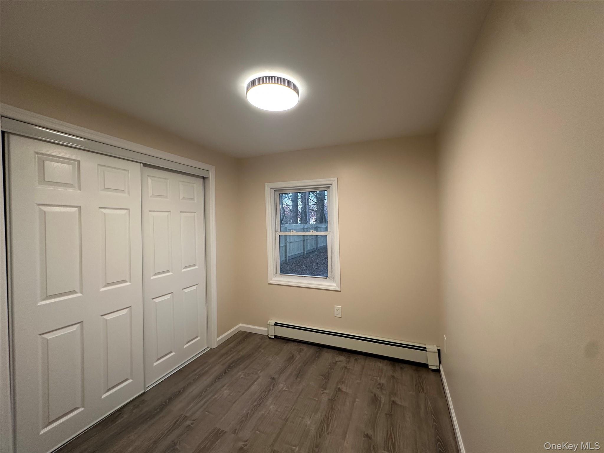 103 Sunrise Trail Wallkill, NY 12589 - Photo 16 of 24 Unfurnished bedroom featuring baseboard heating, dark wood-type flooring, and a closet