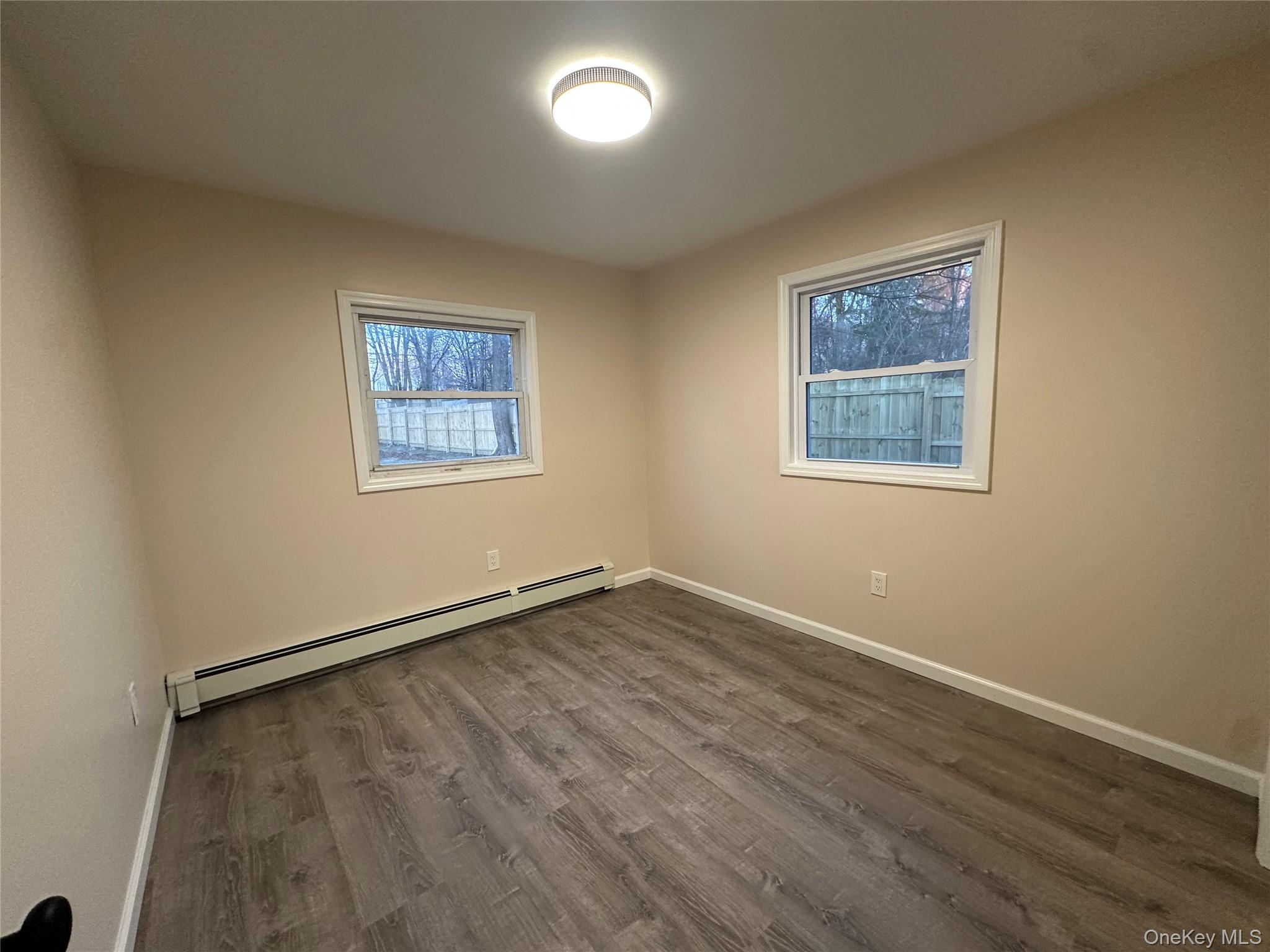 103 Sunrise Trail Wallkill, NY 12589 - Photo 17 of 24 Spare room with a baseboard radiator and dark wood-style floors