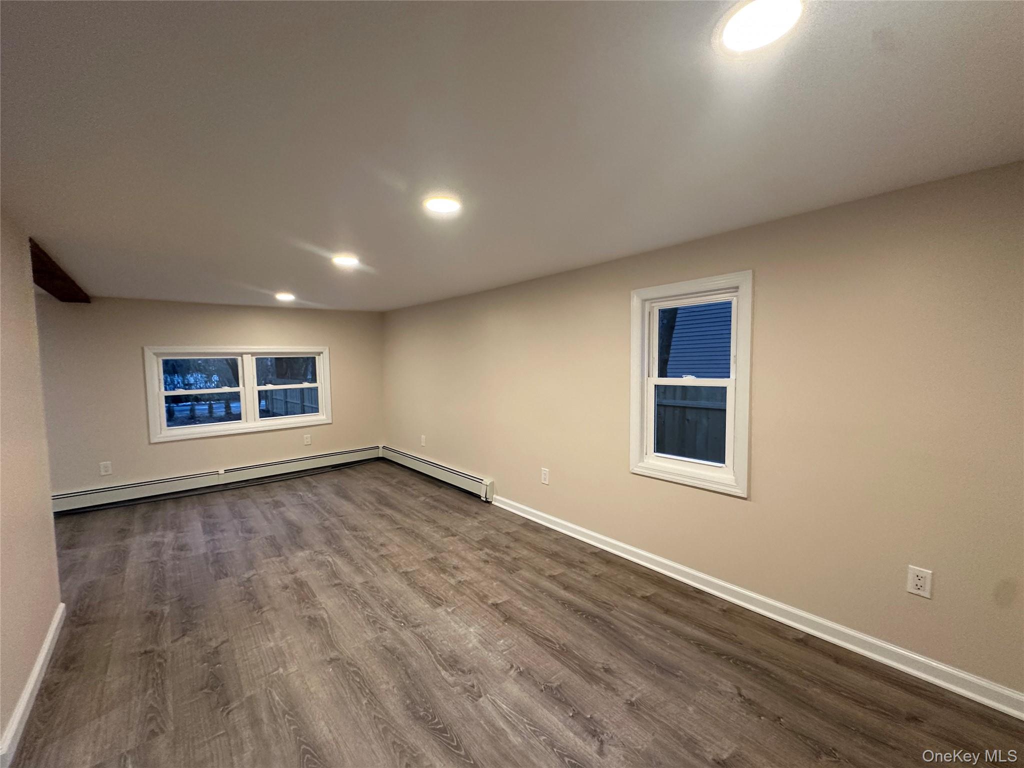 103 Sunrise Trail Wallkill, NY 12589 - Photo 19 of 24 Empty room featuring recessed lighting, dark wood finished floors, and a baseboard radiator