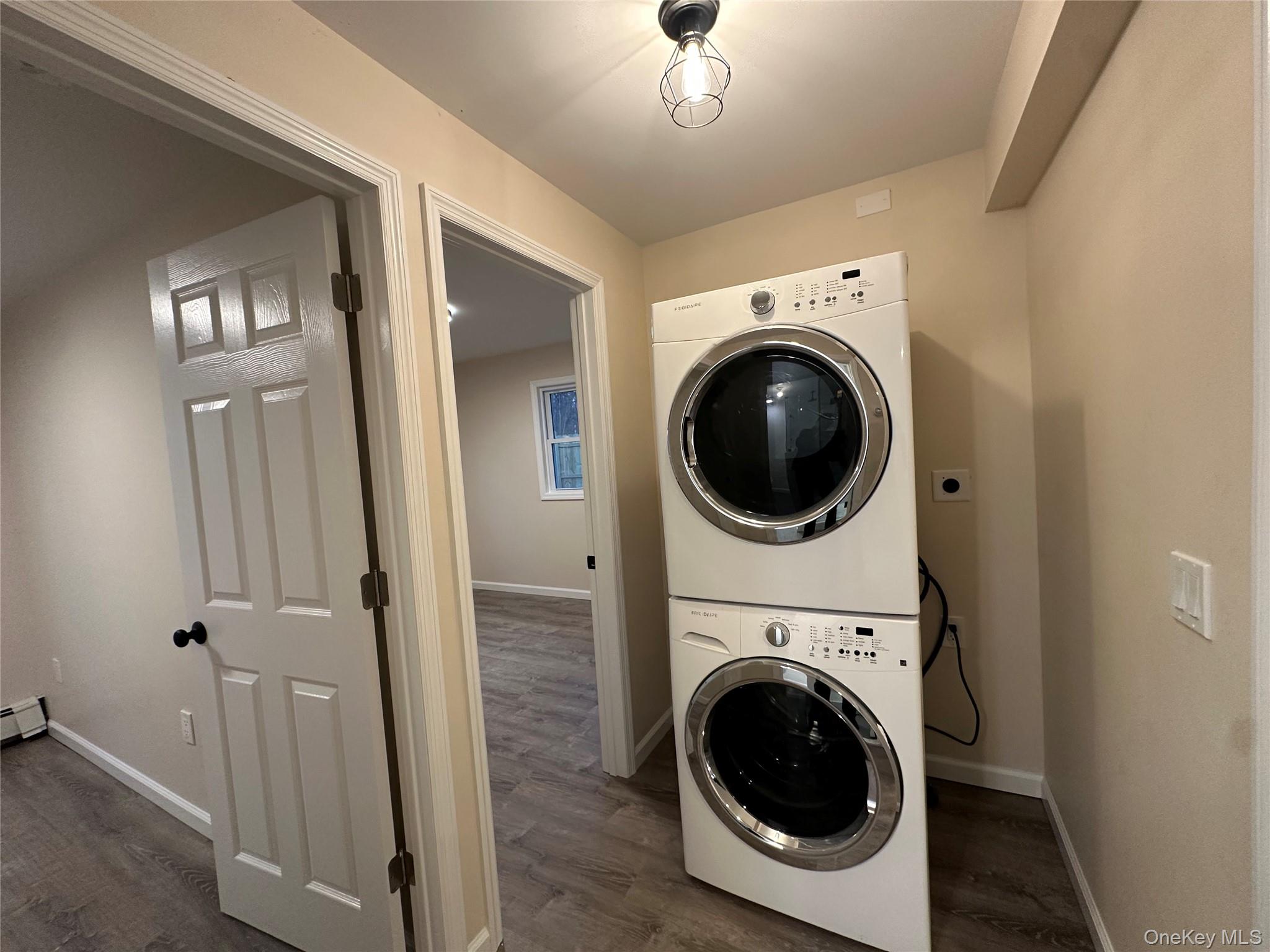 103 Sunrise Trail Wallkill, NY 12589 - Photo 20 of 24 Laundry area featuring stacked washer and clothes dryer and dark wood-style floors