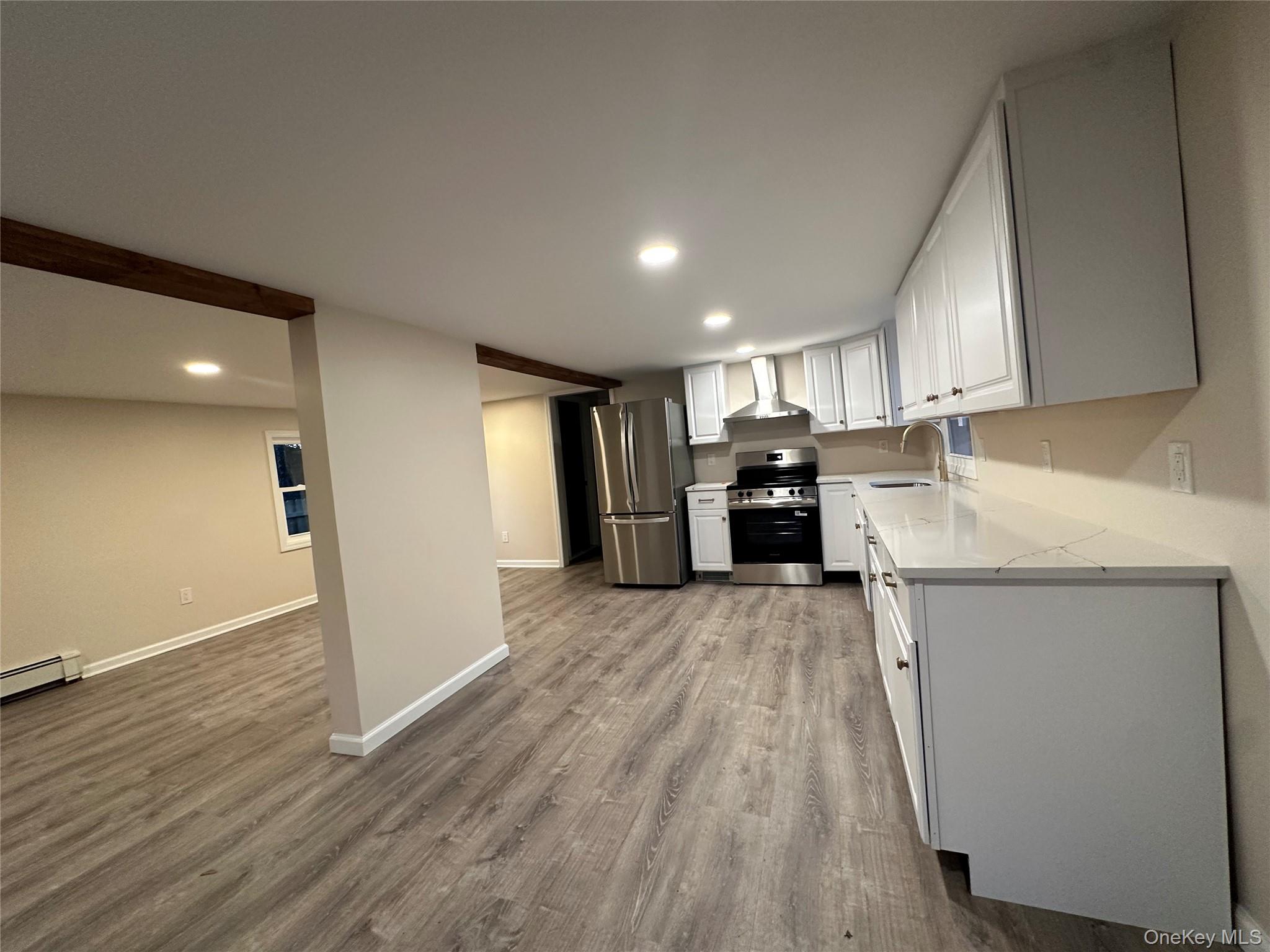 103 Sunrise Trail Wallkill, NY 12589 - Photo 10 of 24 Kitchen with white cabinets, appliances with stainless steel finishes, recessed lighting, dark wood-type flooring, and wall chimney range hood