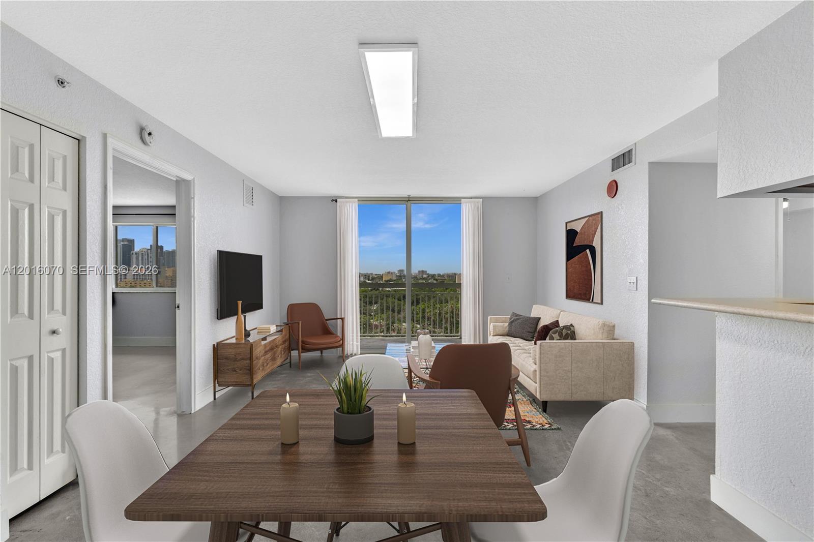 a living room with furniture a large window and a dining table