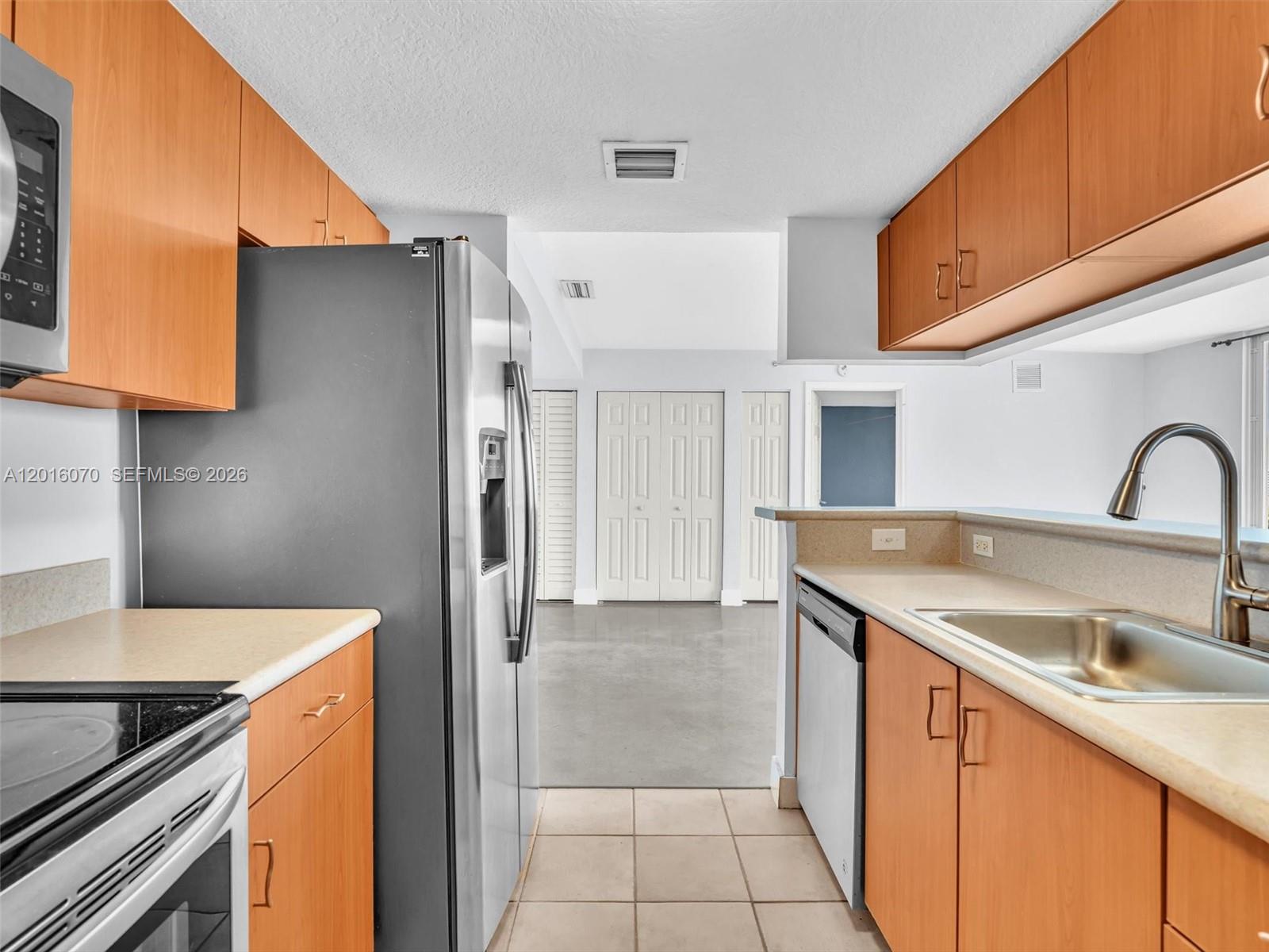 816 Northwest 11th Street, Unit 1208 Miami, FL 33136 - Photo 14 of 49 a kitchen with a sink a refrigerator and cabinets