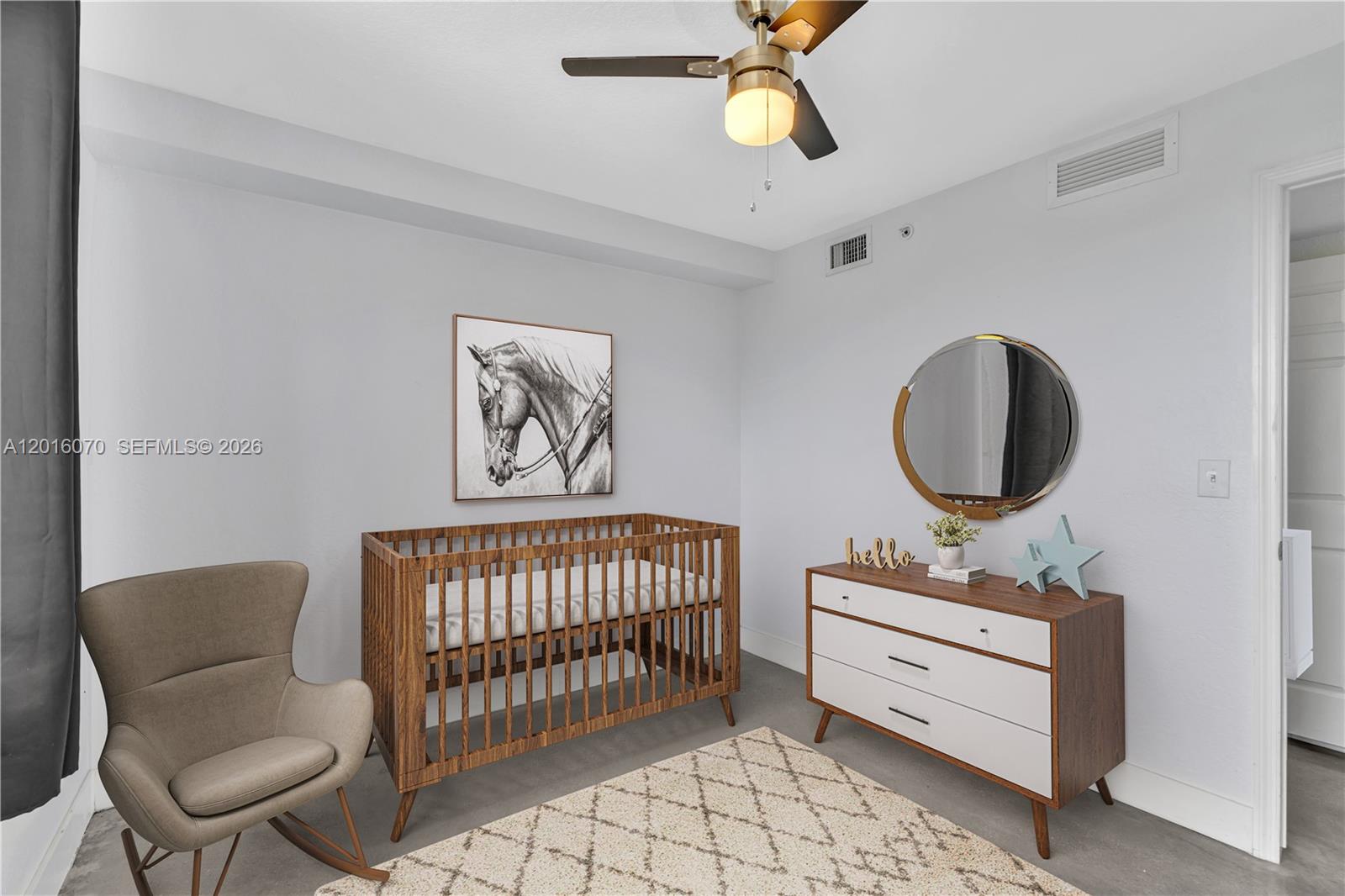 816 Northwest 11th Street, Unit 1208 Miami, FL 33136 - Photo 27 of 49 a bedroom with a baby bed a couch and a chandelier