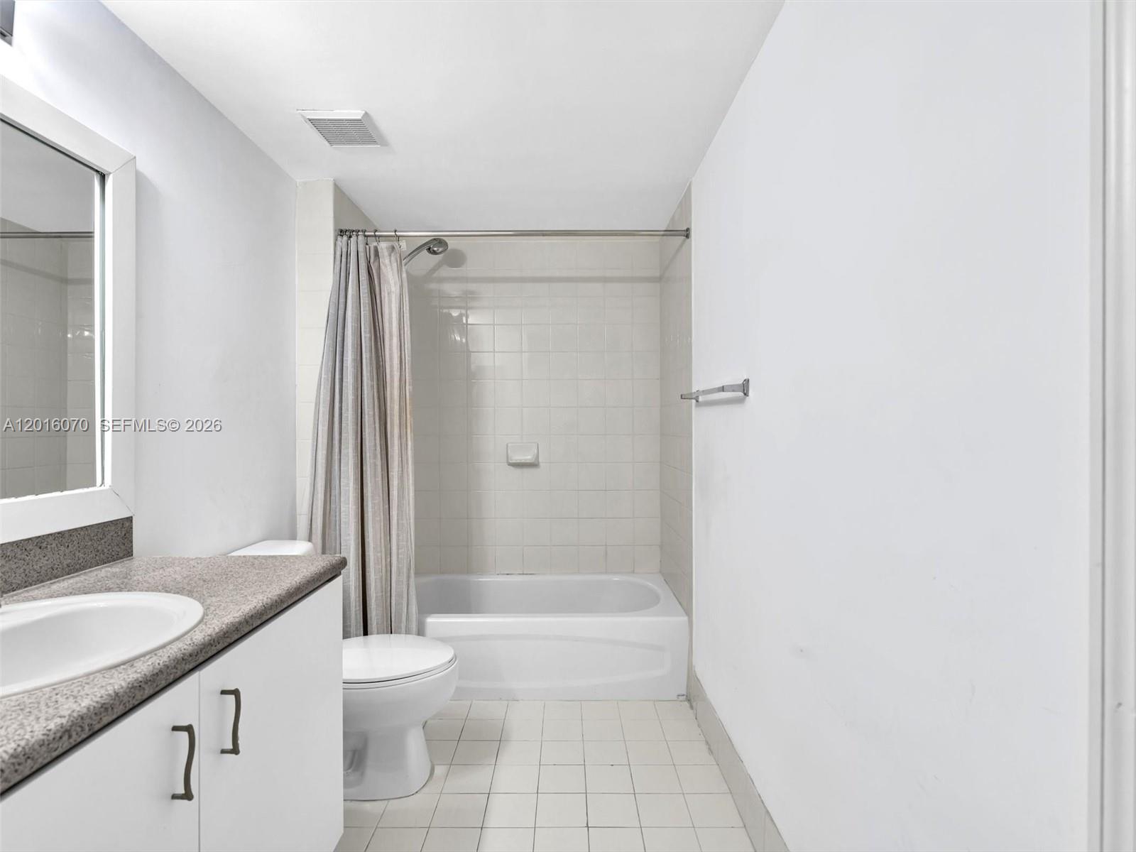 816 Northwest 11th Street, Unit 1208 Miami, FL 33136 - Photo 30 of 49 a bathroom with a granite countertop sink a toilet and shower