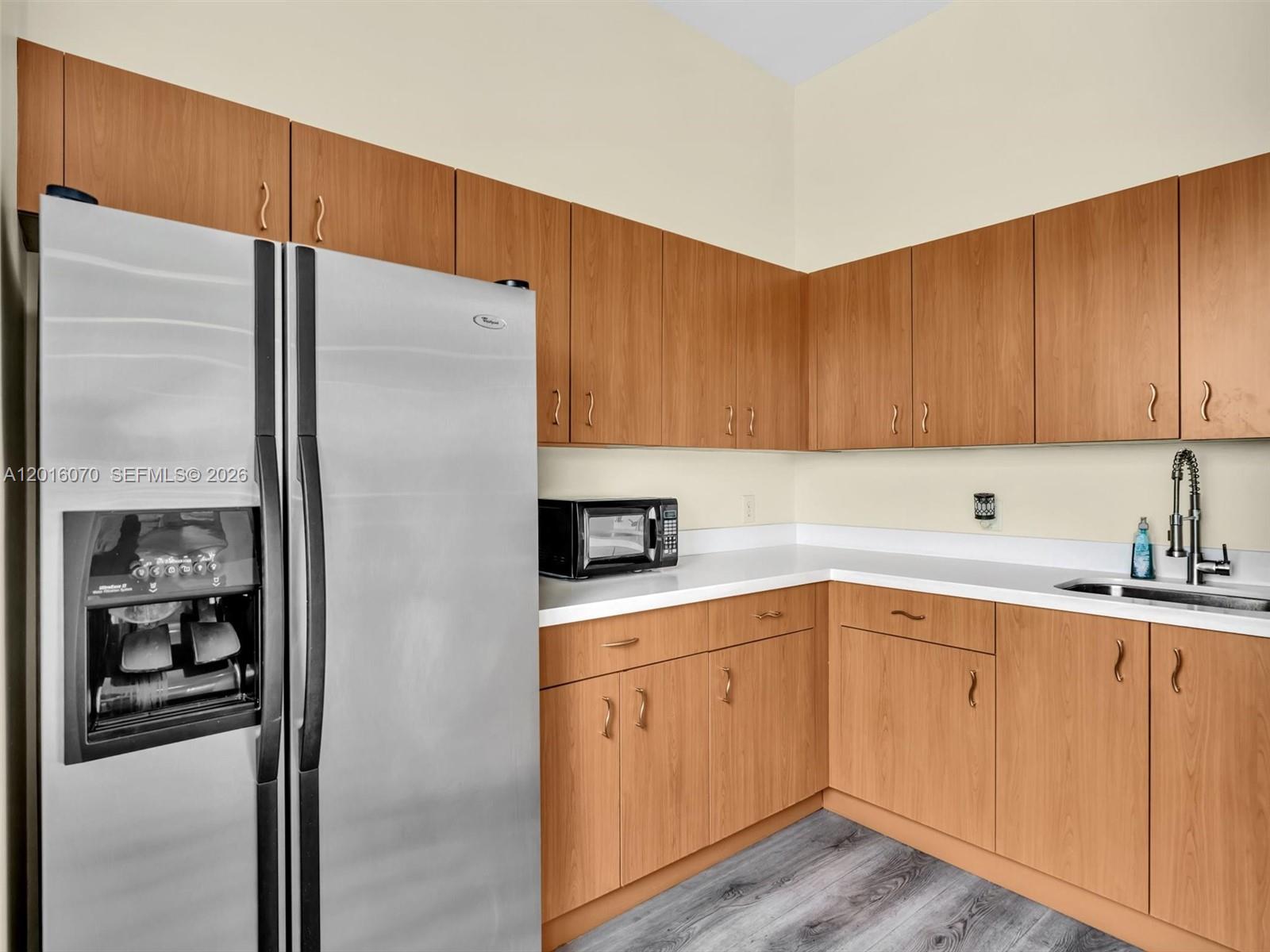 816 Northwest 11th Street, Unit 1208 Miami, FL 33136 - Photo 41 of 49 a kitchen with a sink a refrigerator and cabinets