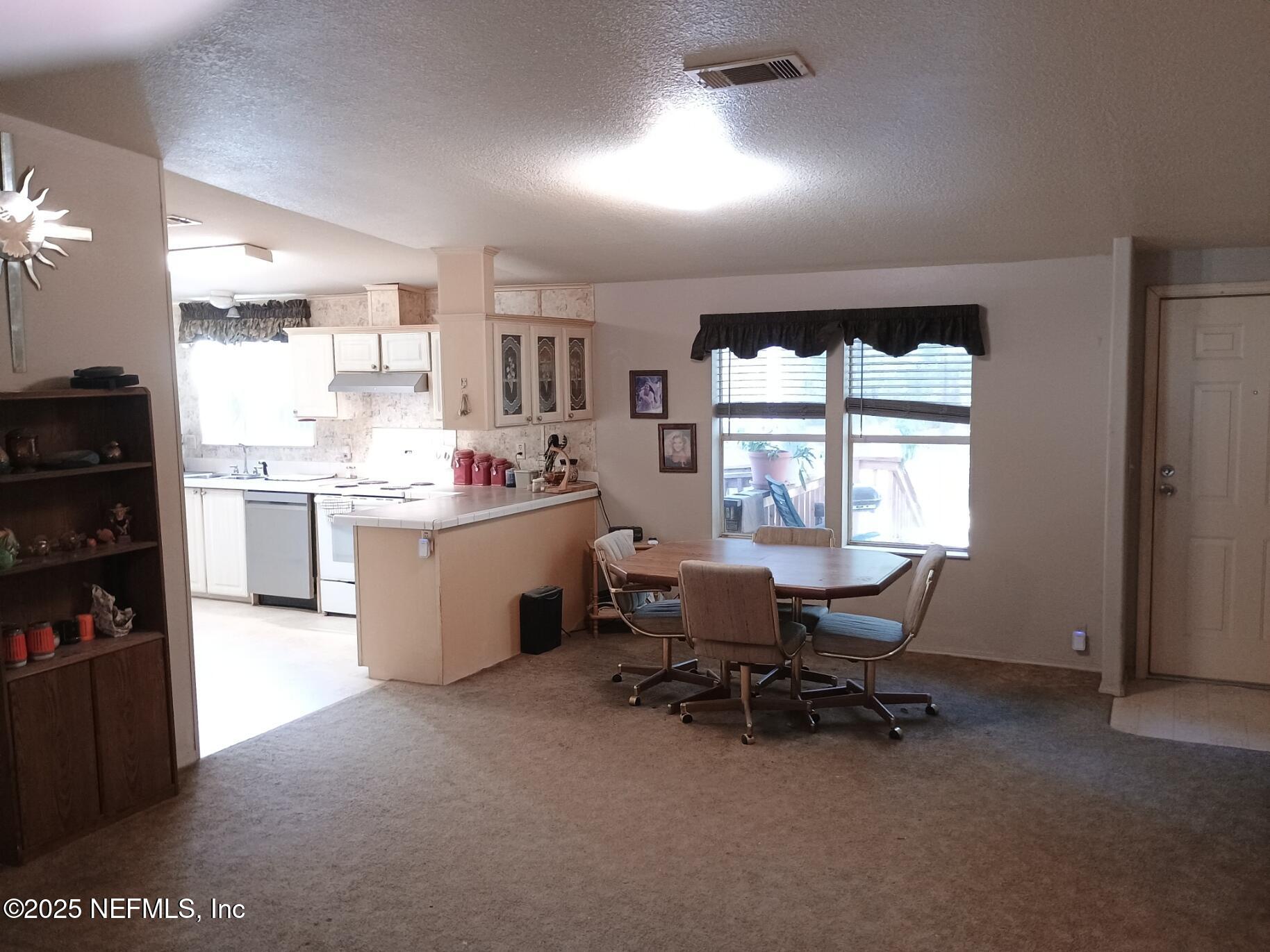 136 Boots Road Melrose, FL 32666 - Photo 12 of 40 a kitchen with a table chairs and a refrigerator