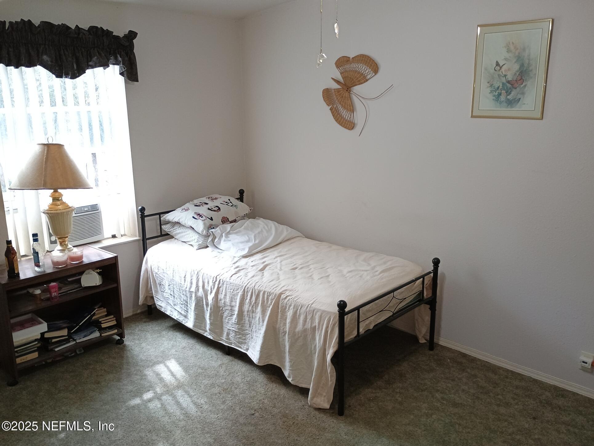 136 Boots Road Melrose, FL 32666 - Photo 16 of 40 a bedroom with a bed and a lamp