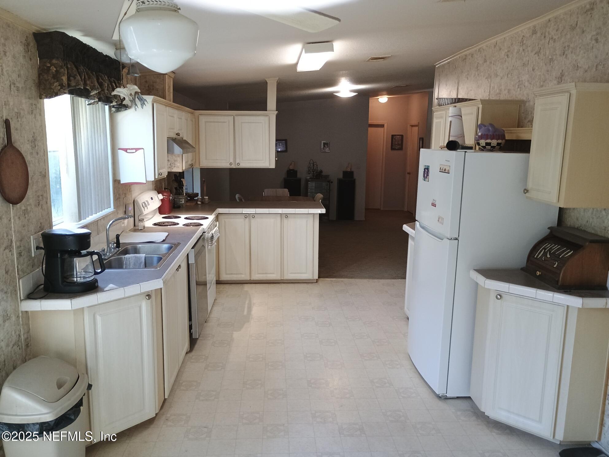 136 Boots Road Melrose, FL 32666 - Photo 17 of 40 a kitchen with refrigerator and cabinets