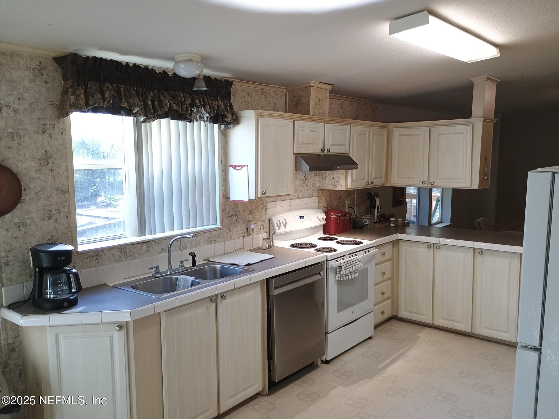 136 Boots Road Melrose, FL 32666 - Photo 18 of 40 a kitchen with a sink stove and cabinets