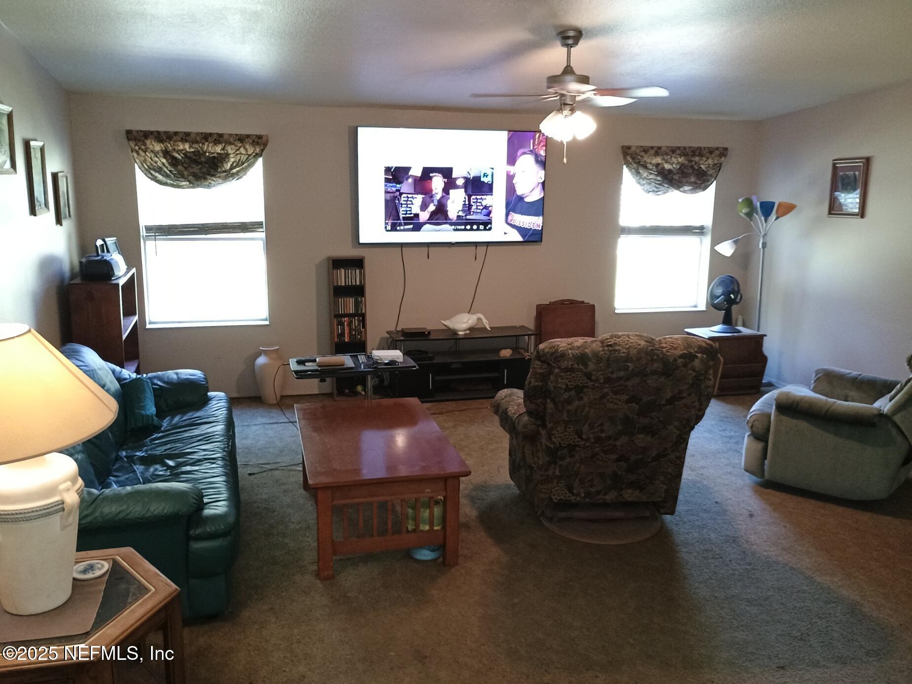 136 Boots Road Melrose, FL 32666 - Photo 22 of 40 a living room with furniture a window and a flat screen tv