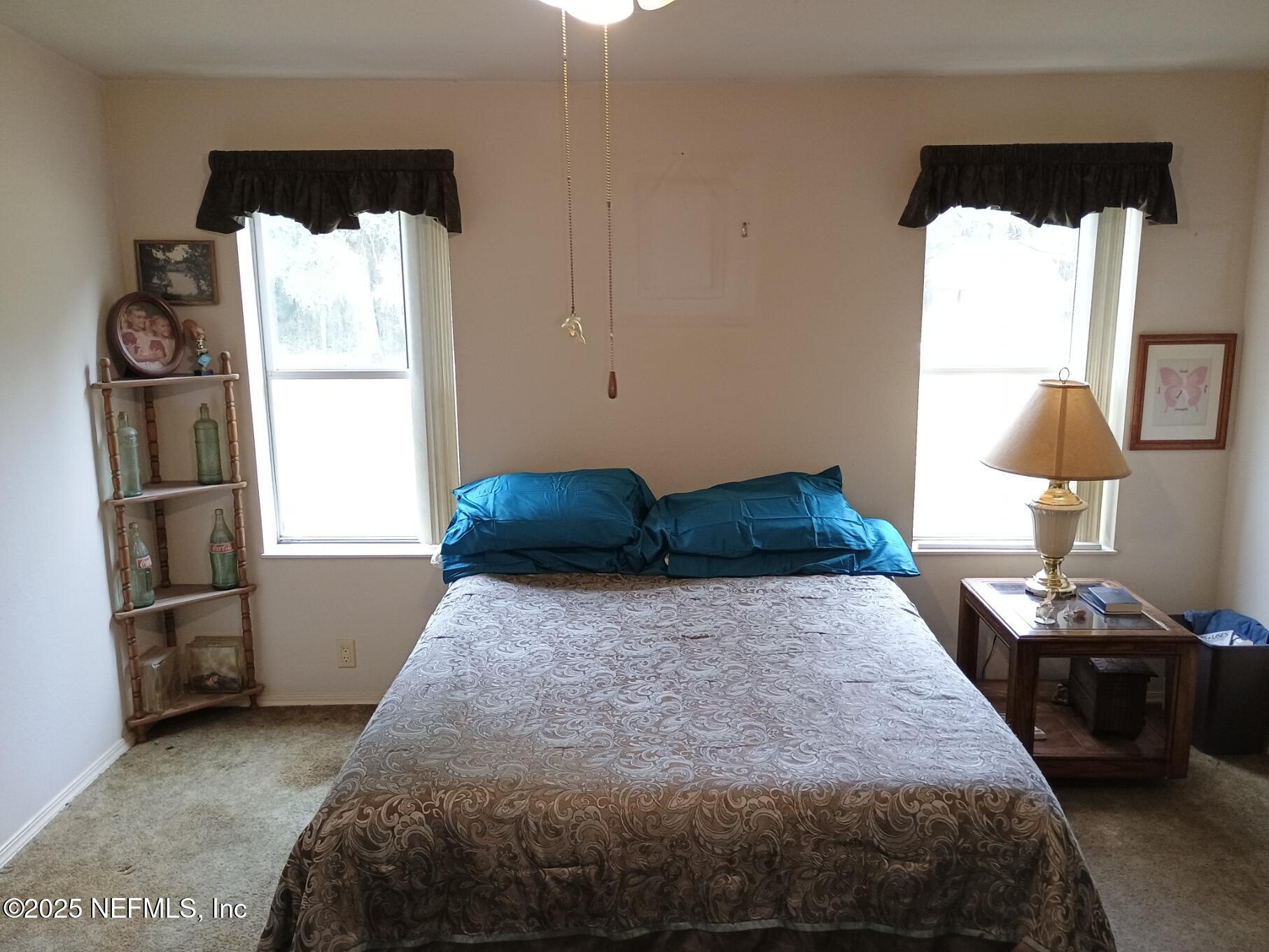 136 Boots Road Melrose, FL 32666 - Photo 23 of 40 a bedroom with a bed and wooden floor