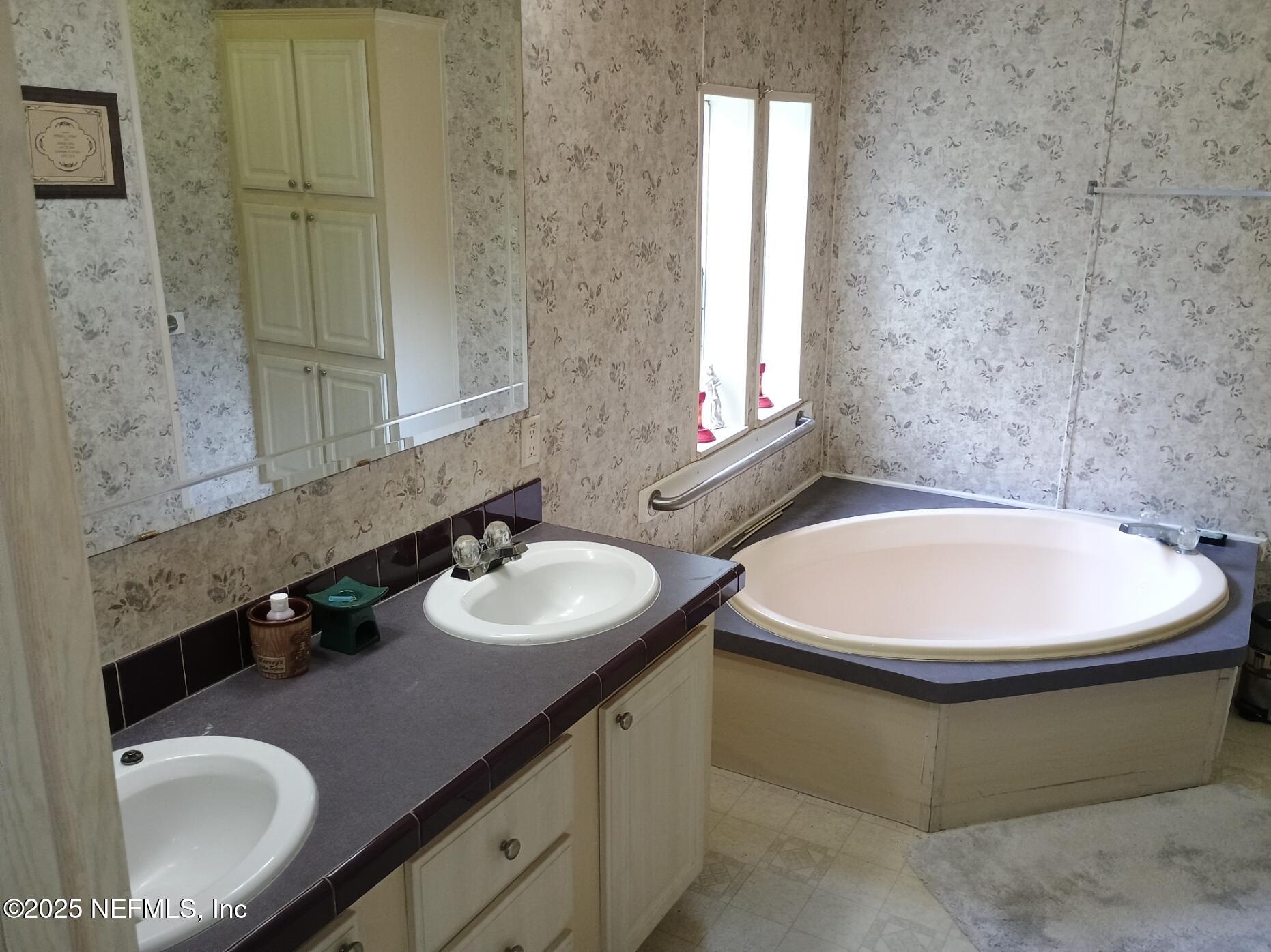 136 Boots Road Melrose, FL 32666 - Photo 24 of 40 a bathroom with a sink and a mirror