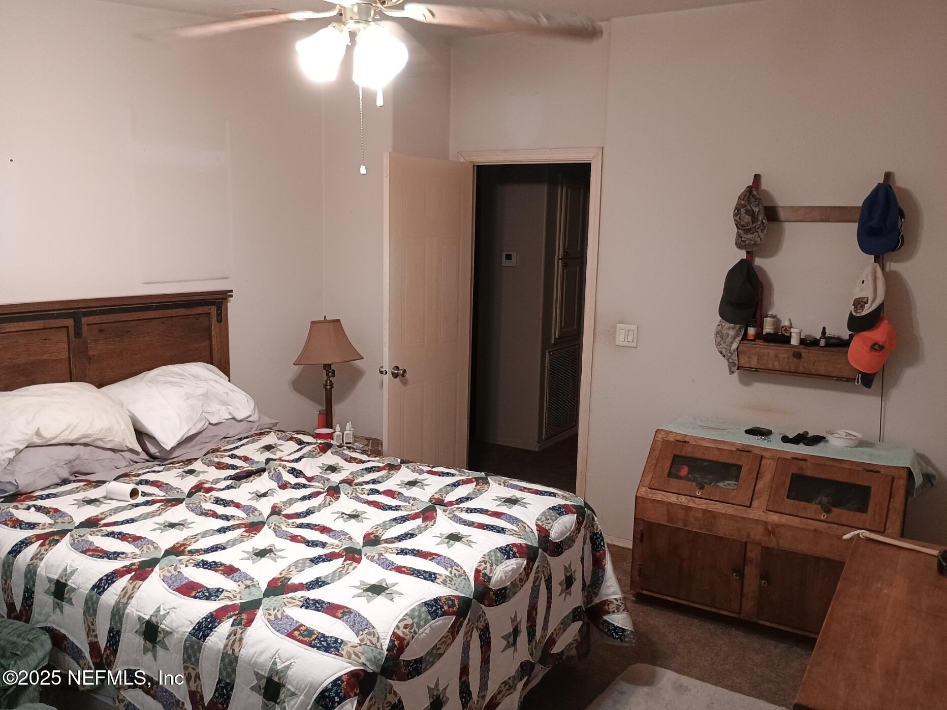 136 Boots Road Melrose, FL 32666 - Photo 27 of 40 a bedroom with a bed and a chandelier