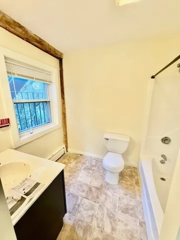 a bathroom with a granite countertop sink a toilet and a shower