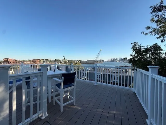 a view of a balcony with wooden floor and fence