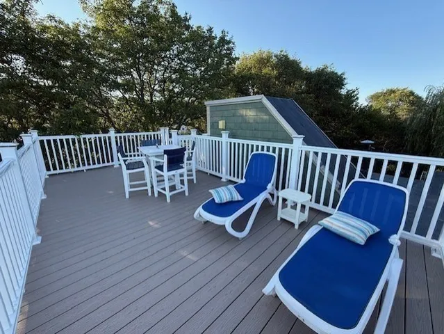 a view of a chair and table on the wooden deck