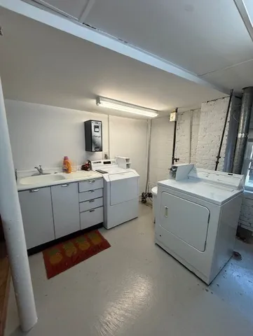 a utility room with sink dryer and washer