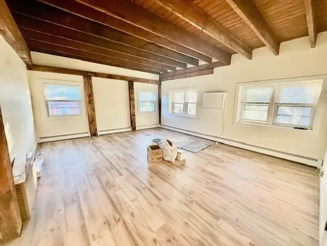 a room with wooden floor and windows