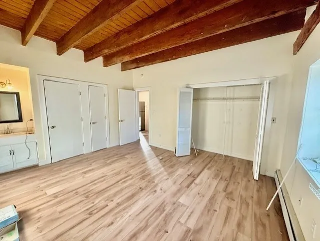 a view of empty room with wooden floor