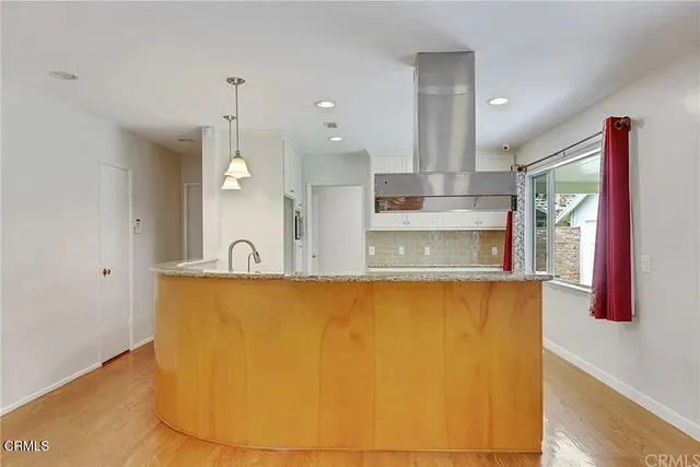 a view of a kitchen with kitchen island a sink a counter top space and stainless steel appliances