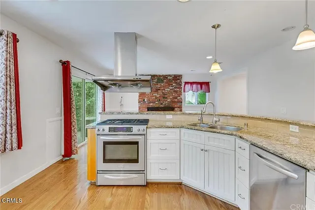 a kitchen with stainless steel appliances granite countertop a stove and a sink