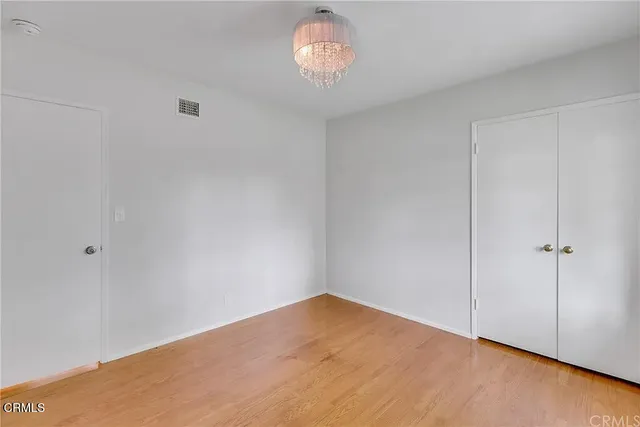 a view of an empty room and chandelier fan