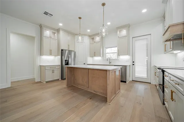 a large white kitchen with a lot of counter space a sink appliances and cabinets