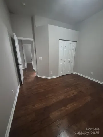 an empty room with wooden floor and stairs