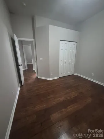 an empty room with wooden floor and stairs