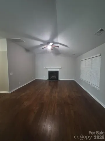 a view of a room with wooden floor and ceiling fan