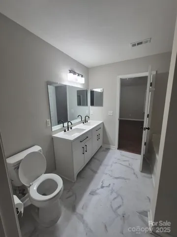 a bathroom with a sink toilet and mirror