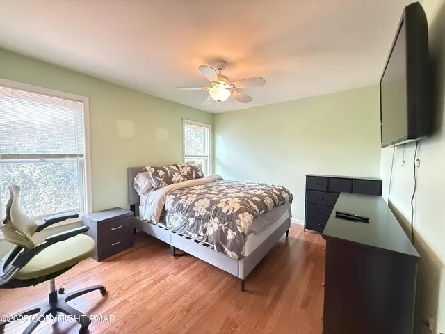 a bedroom with a bed window and a flat screen tv